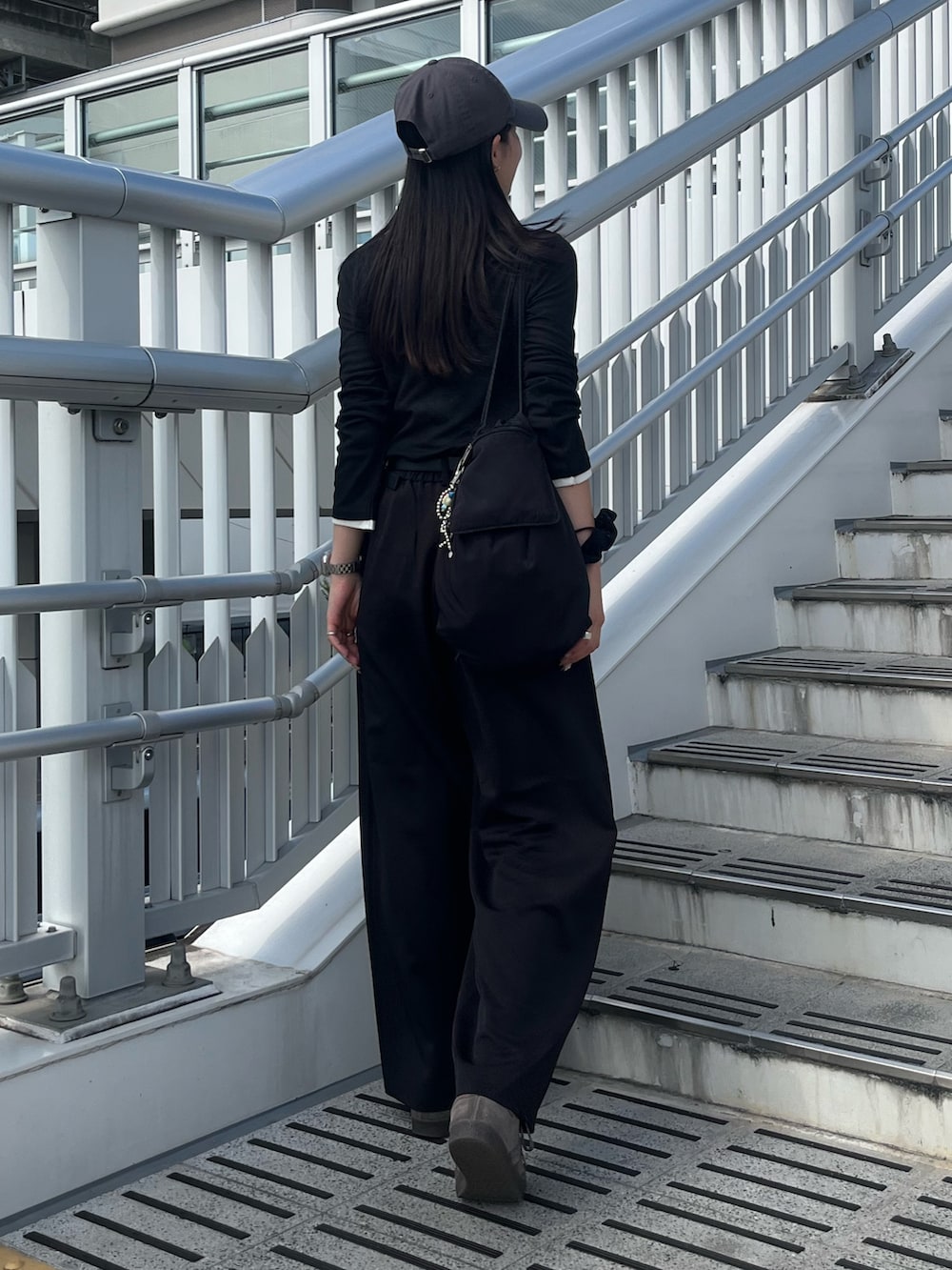 ブラック系のバックパック/リュック、ブラック系のTシャツ/カットソー、ブラック系のスラックスを着用したレディースの秋コーディネートの2枚目の写真