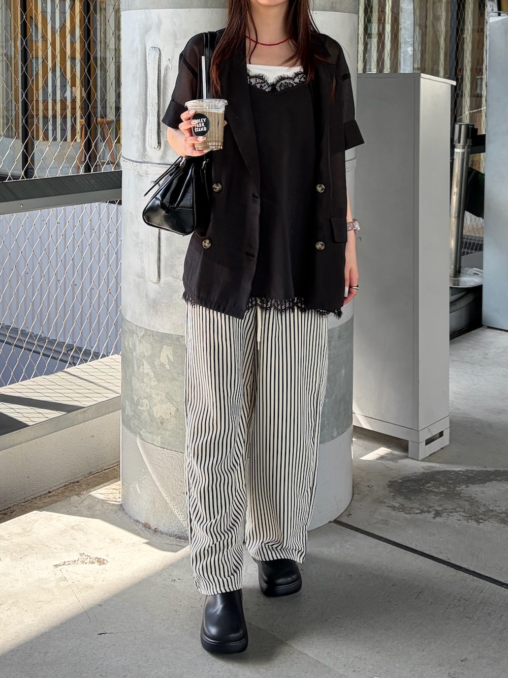 ブラック系のサンダル、ブルー系のその他パンツ、ブラック系のシャツ/ブラウスを着用したレディースの夏コーディネートの2枚目の写真