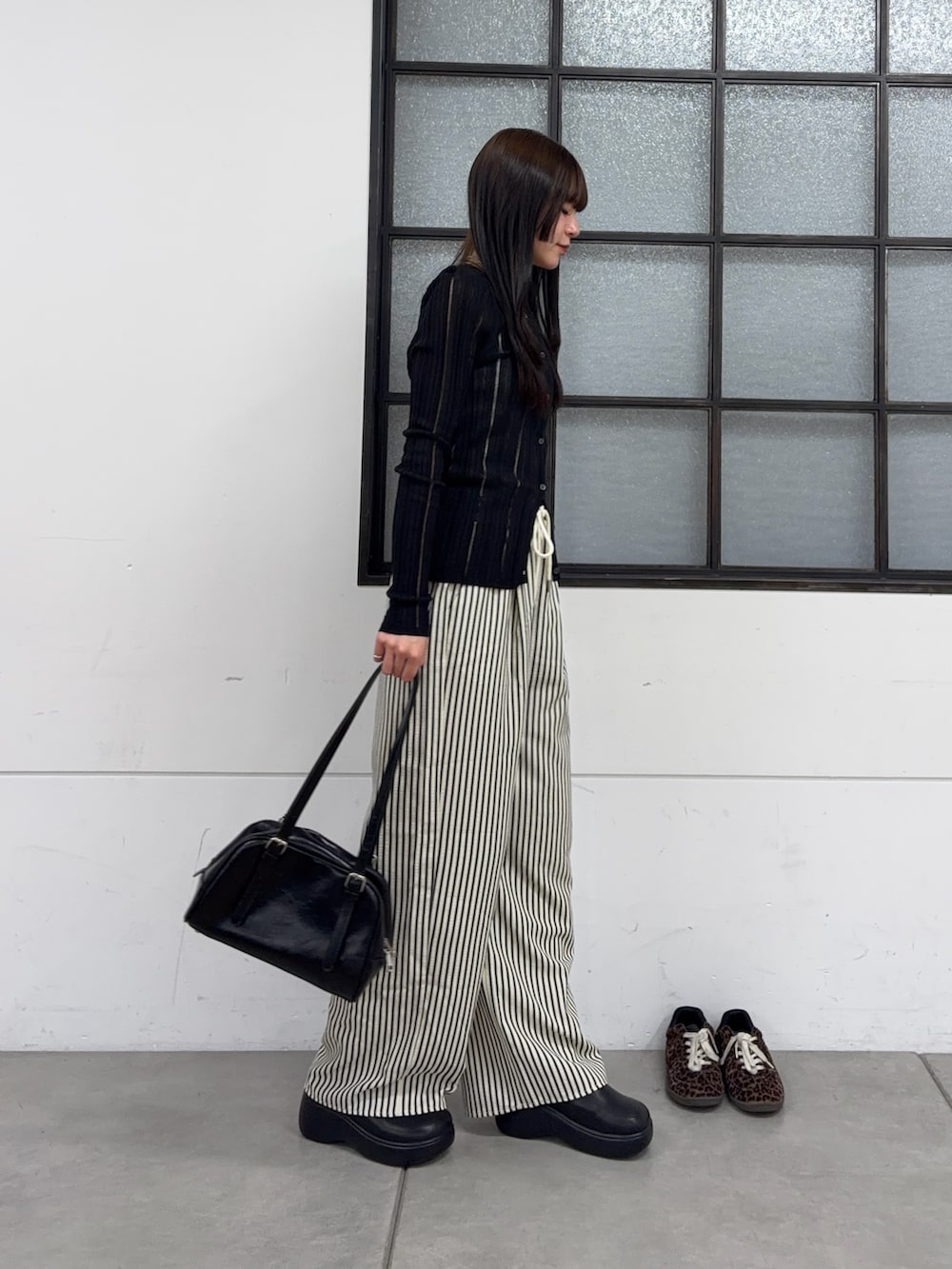 ブラック系のボストンバッグ、ブラック系のサンダル、ブルー系のその他パンツを着用したレディースの春コーディネートの2枚目の写真