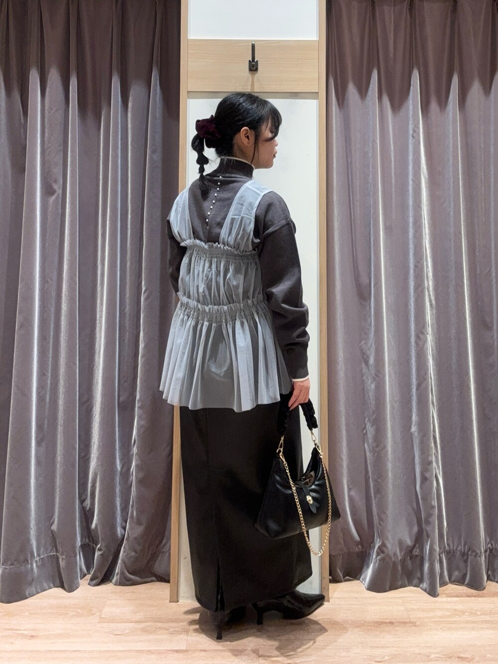 ブラック系のハンドバッグ、グレー系のニット/セーター、グレー系のシャツ/ブラウスを着用したレディースの冬コーディネートの4枚目の写真