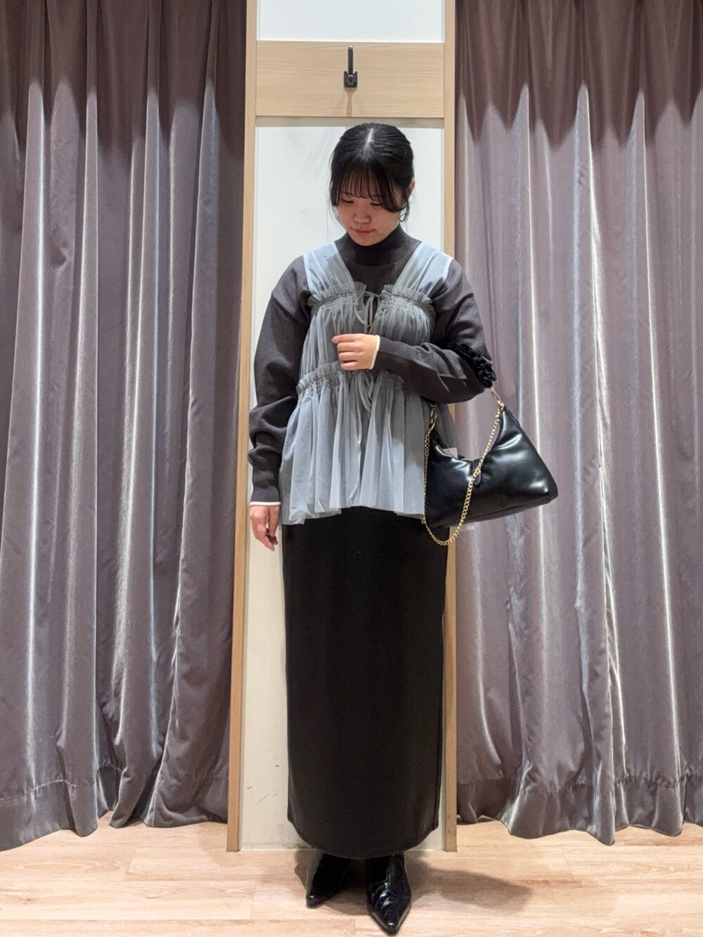 ブラック系のハンドバッグ、グレー系のニット/セーター、グレー系のシャツ/ブラウスを着用したレディースの冬コーディネートの3枚目の写真