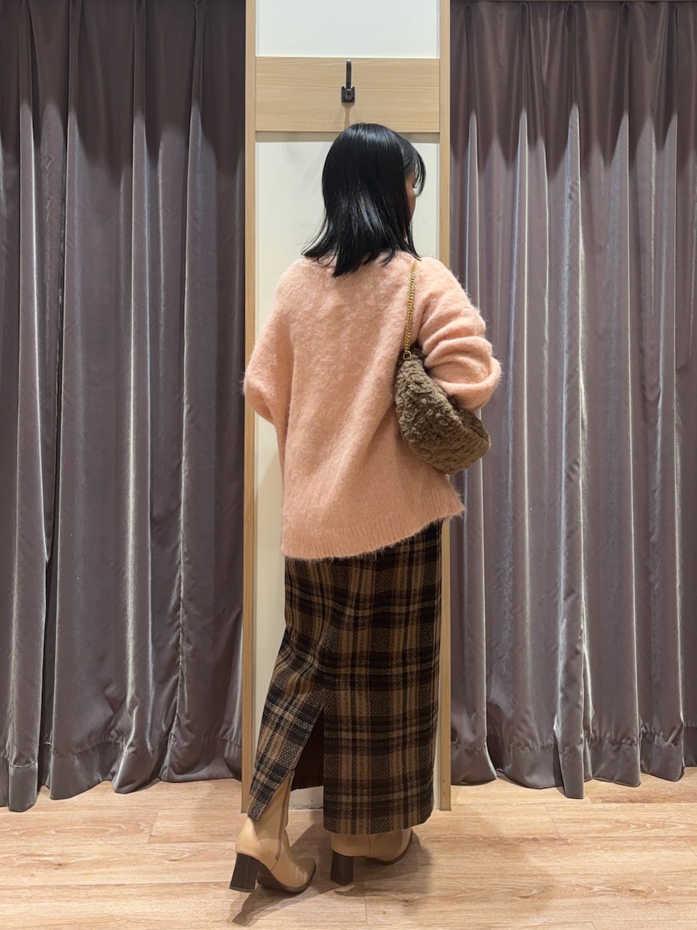 ピンク系のカーディガン/ボレロ、ホワイト系のTシャツ/カットソー、ブラウン系のスカートを着用したレディースの冬コーディネートの2枚目の写真