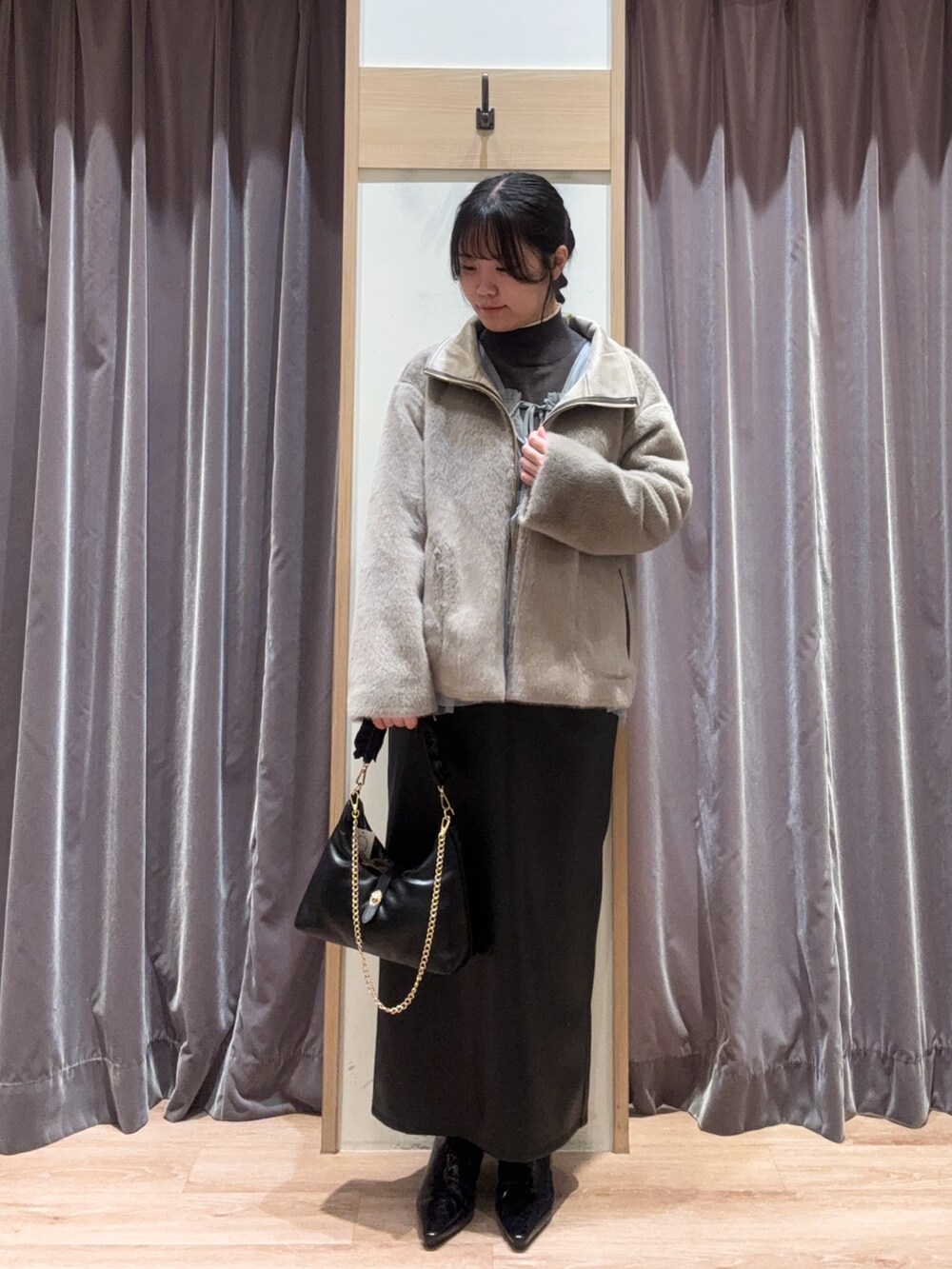ブラック系のハンドバッグ、グレー系のニット/セーター、グレー系のシャツ/ブラウスを着用したレディースの冬コーディネートの2枚目の写真