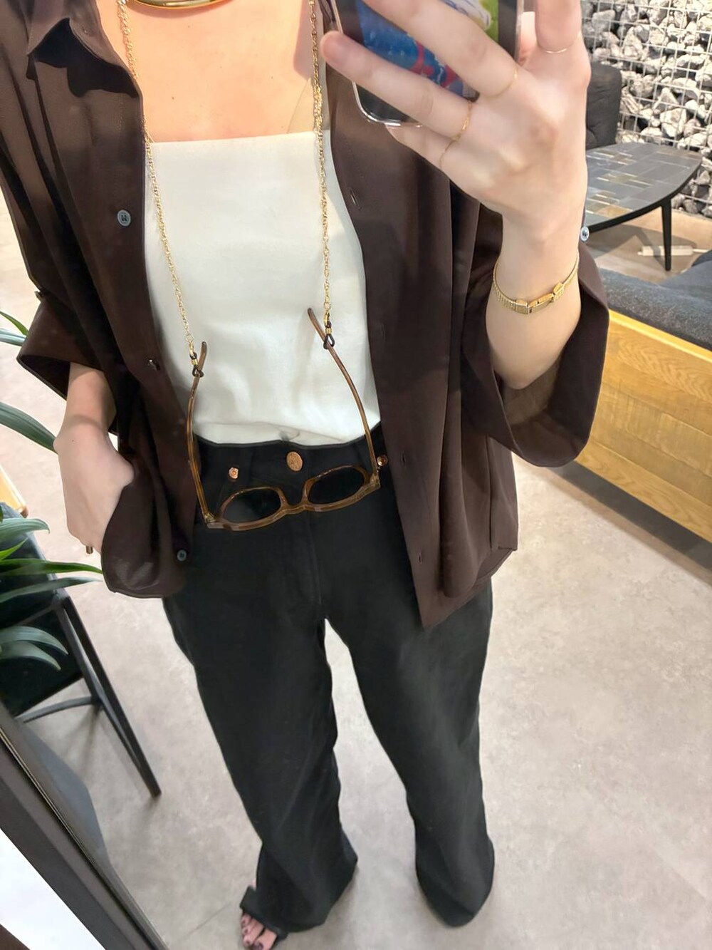 ブラック系のデニムパンツ、ベージュ系のトートバッグ、ブラウン系のシャツ/ブラウスを着用したレディースの春コーディネートの6枚目の写真