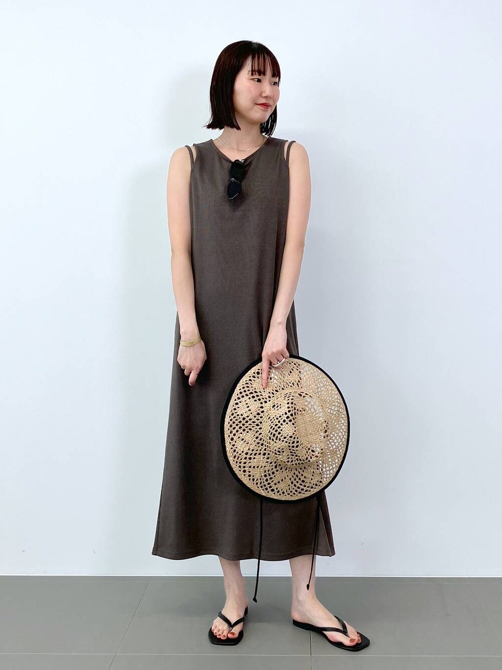 ブラック系のサンダル、ブラウン系のワンピース、ベージュ系のハットを着用したレディースの夏コーディネートの3枚目の写真