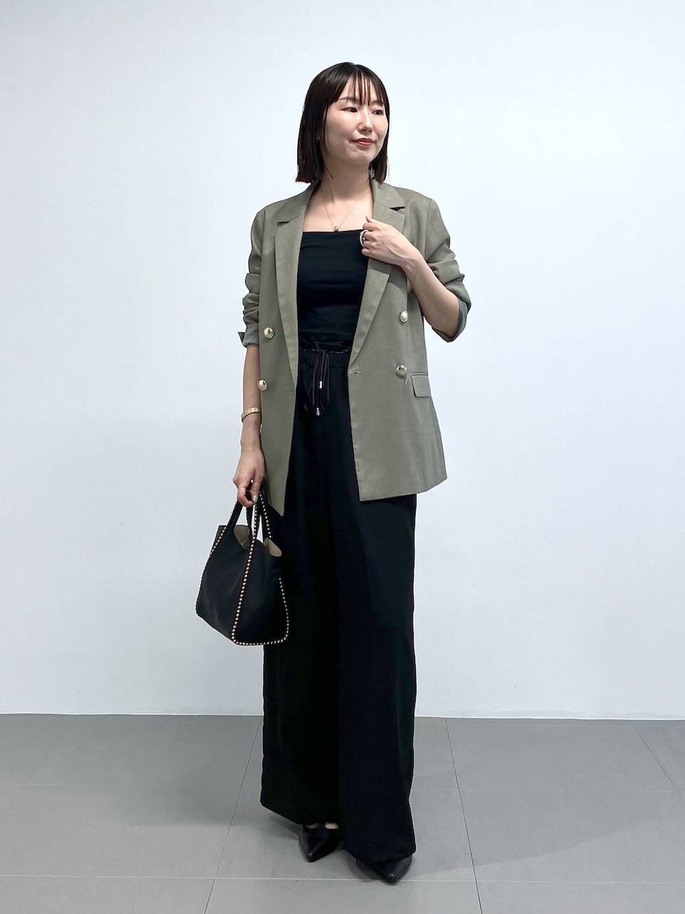 ブラック系のトートバッグ、グリーン系のテーラードジャケット、ブラック系のその他パンツを着用したレディースの夏コーディネートの2枚目の写真