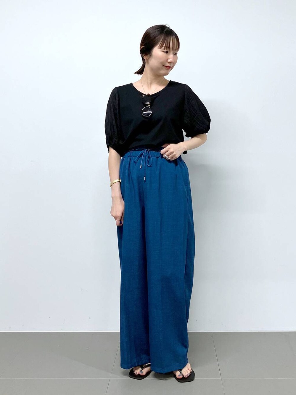 ブラック系のサンダル、ブルー系のその他パンツ、ブラック系のTシャツ/カットソーを着用したレディースの夏コーディネートの3枚目の写真