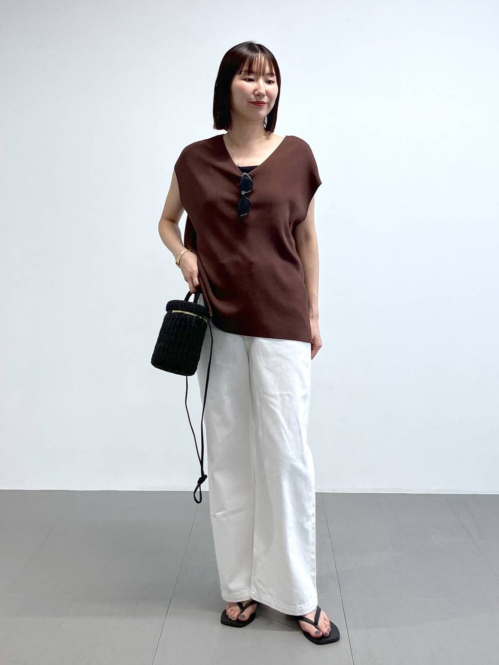 ブラック系のショルダーバッグ、ホワイト系のデニムパンツ、ブラック系のサンダルを着用したレディースの夏コーディネートの2枚目の写真