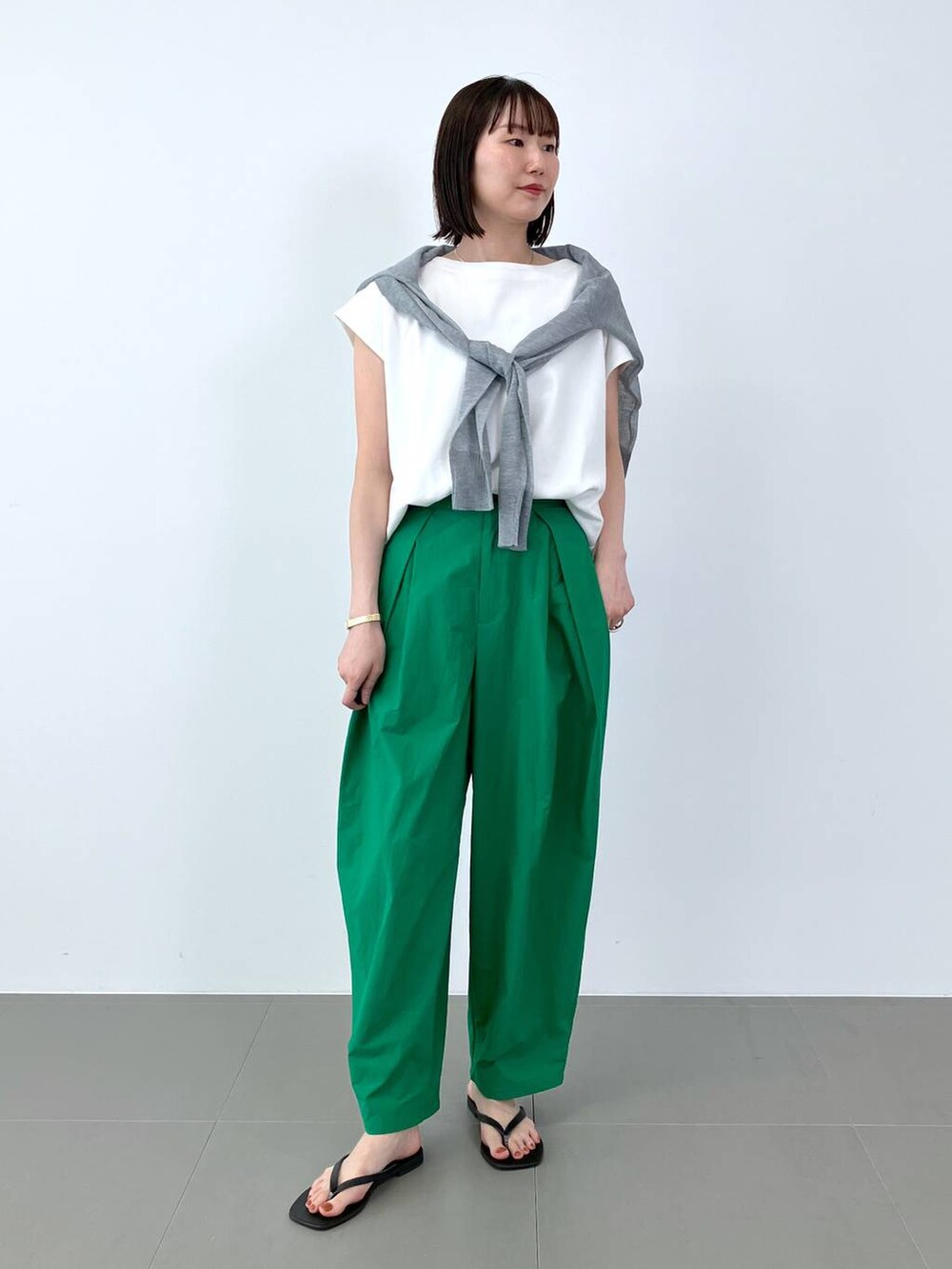 グリーン系のその他パンツ、ブラック系のサンダル、ホワイト系のTシャツ/カットソーを着用したレディースの夏コーディネートの3枚目の写真