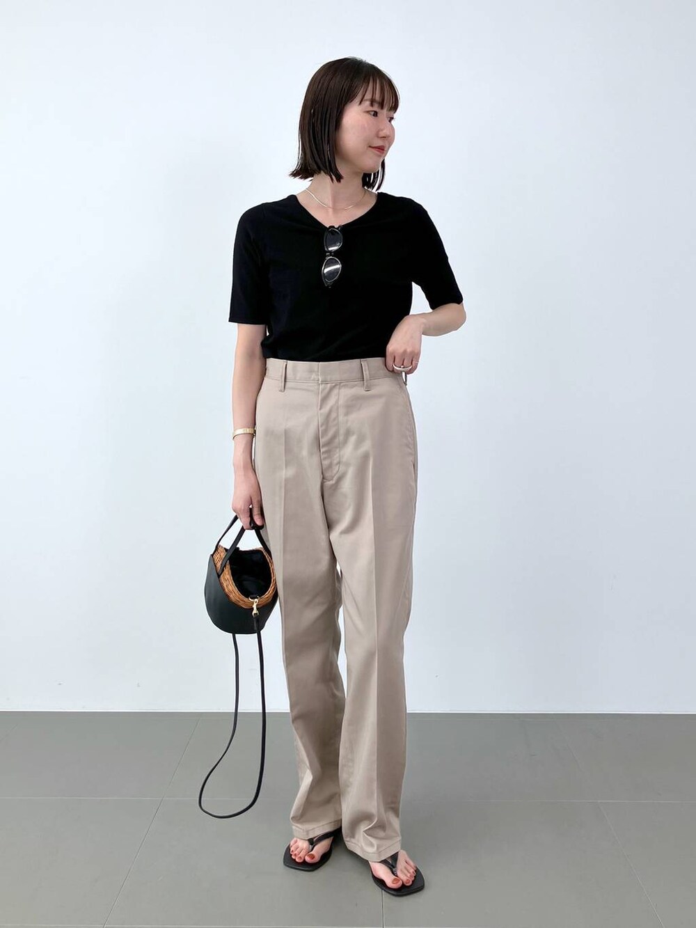 ブラック系のかごバッグ、ブラック系のサンダル、ブラック系のTシャツ/カットソーを着用したレディースの夏コーディネートの3枚目の写真