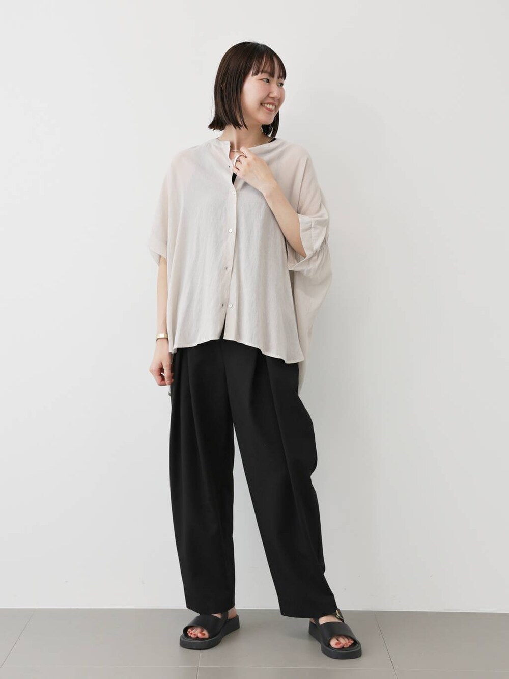 ブラック系のスラックス、ブラック系のタンクトップ、ホワイト系のシャツ/ブラウスを着用したレディースの夏コーディネートの3枚目の写真