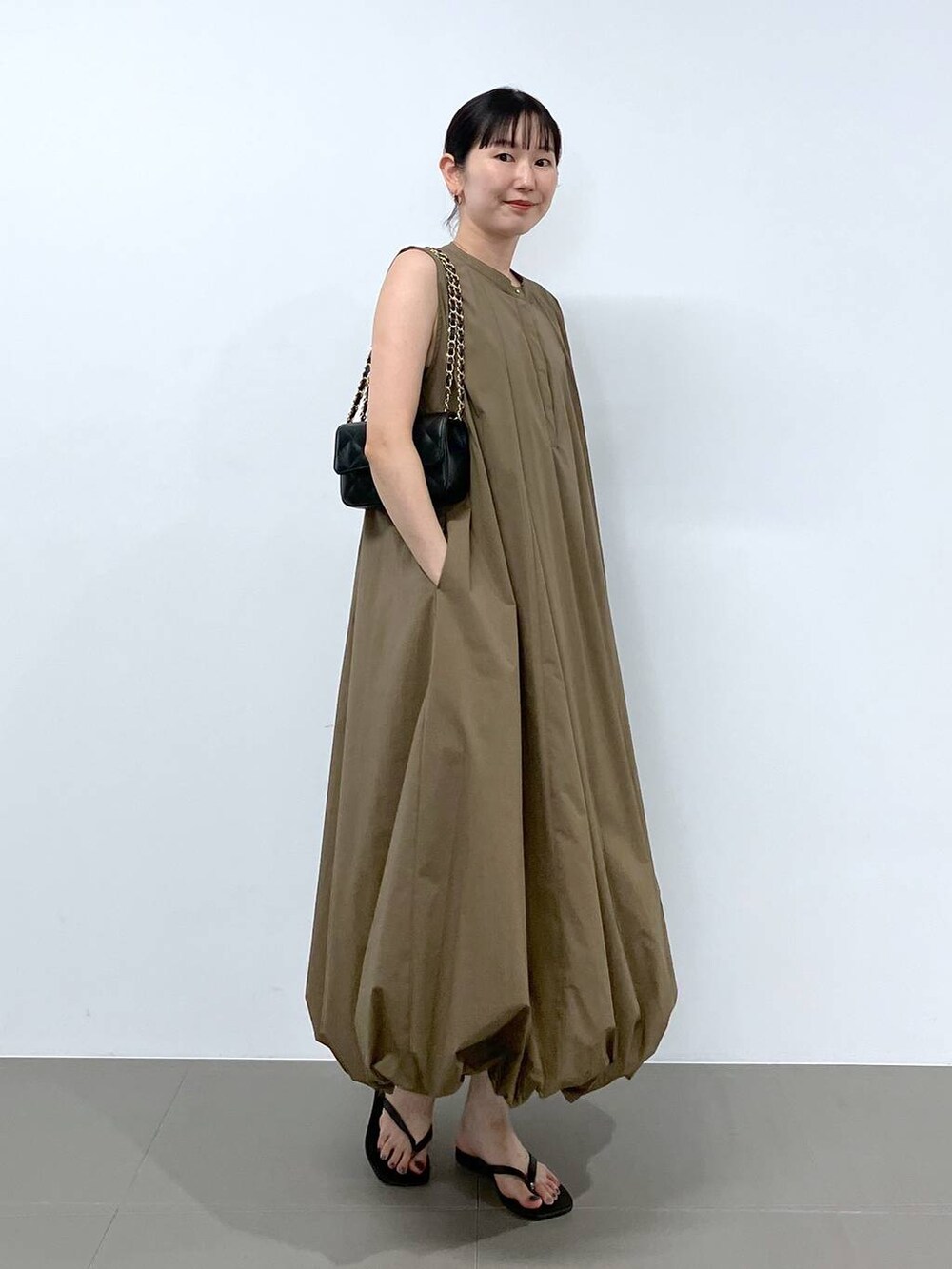 ブラック系のショルダーバッグ、ブラック系のサンダルを着用したレディースの夏コーディネートの2枚目の写真