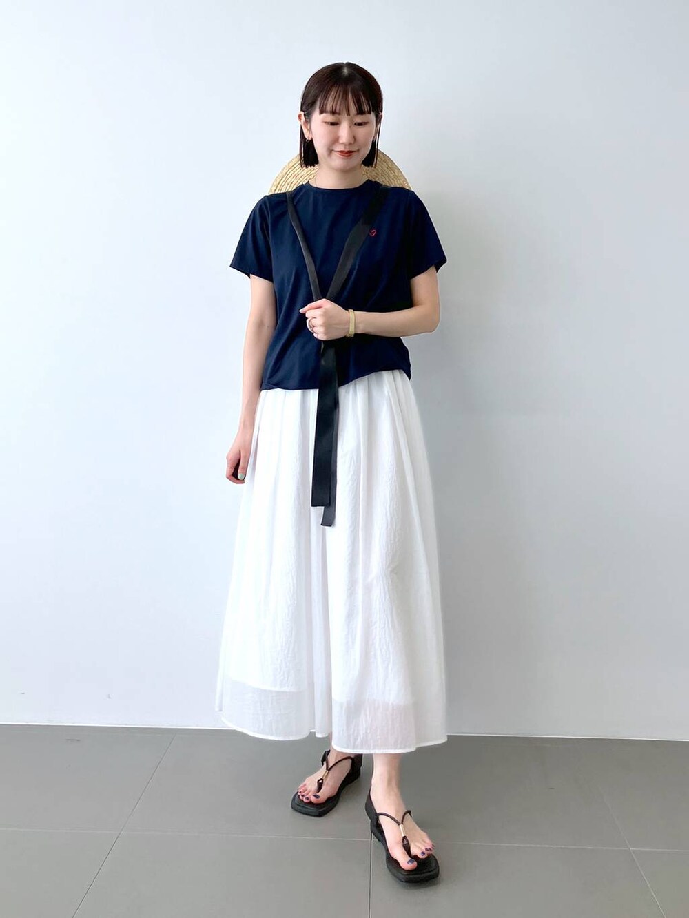 ブルー系のTシャツ/カットソー、ホワイト系のスカート、ベージュ系のハットを着用したレディースの夏コーディネートの3枚目の写真