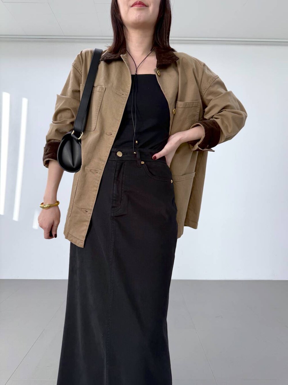 ブラック系のスカート、その他のブーツ、ブラック系のショルダーバッグを着用したレディースの冬コーディネートの3枚目の写真