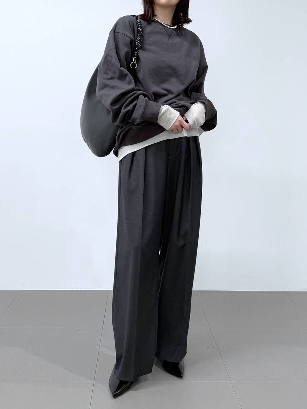 グレー系のTシャツ/カットソー、グレー系のスラックス、グレー系のスウェットを着用したレディースの冬コーディネートの4枚目の写真