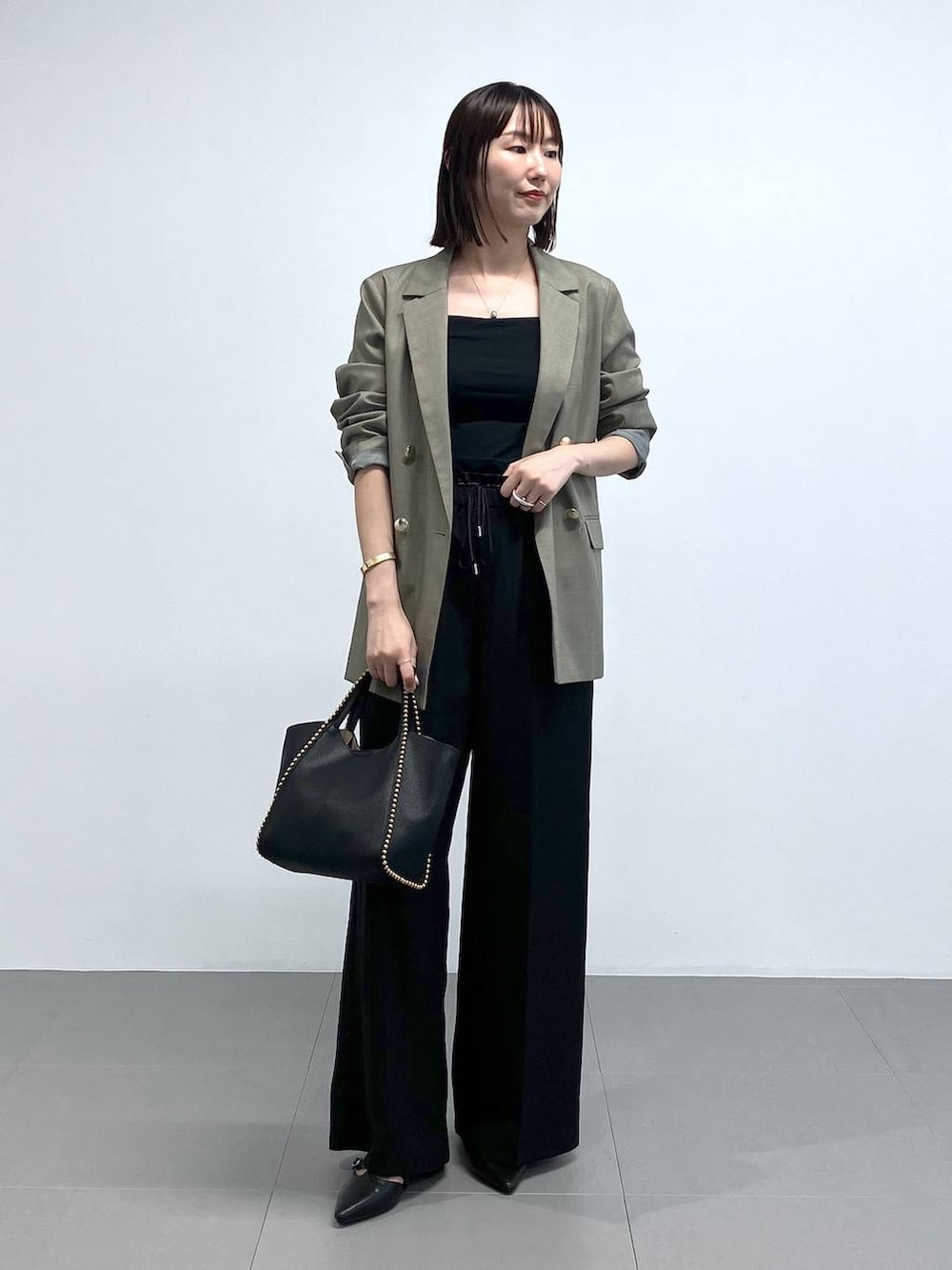 ブラック系のトートバッグ、グリーン系のテーラードジャケット、ブラック系のその他パンツを着用したレディースの夏コーディネートの3枚目の写真
