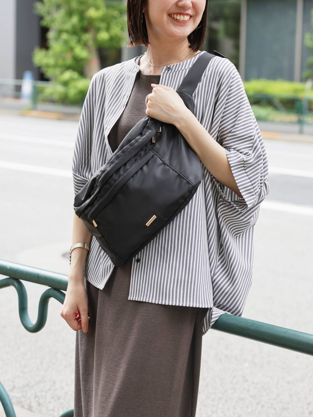 ブラック系のショルダーバッグ、グレー系のシャツ/ブラウス、ブラウン系のワンピースを着用したレディースの夏コーディネートの4枚目の写真