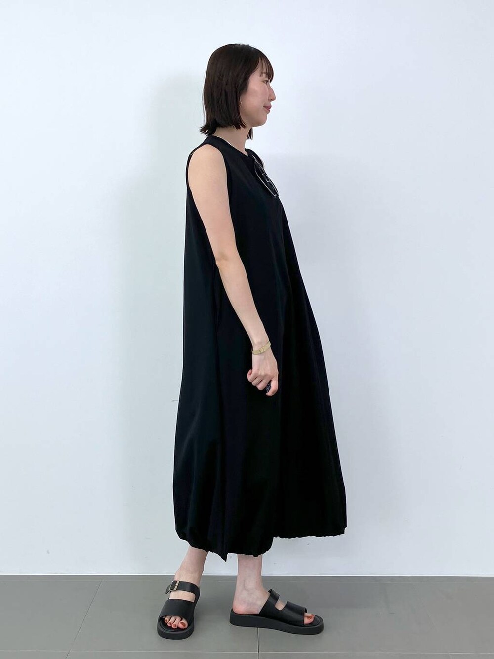 ブラック系のワンピースを着用したレディースの夏コーディネートの2枚目の写真