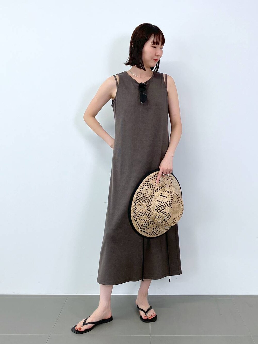 ブラック系のサンダル、ブラウン系のワンピース、ベージュ系のハットを着用したレディースの夏コーディネートの2枚目の写真