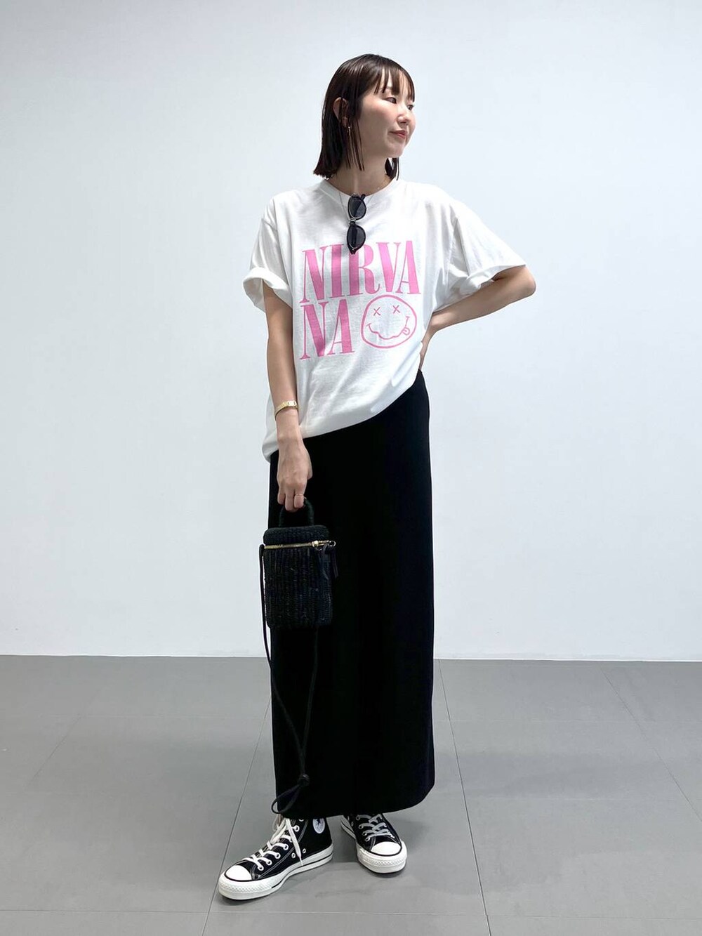 ブラック系のショルダーバッグ、ブラック系のスニーカー、ホワイト系のTシャツ/カットソーを着用したレディースの夏コーディネートの2枚目の写真