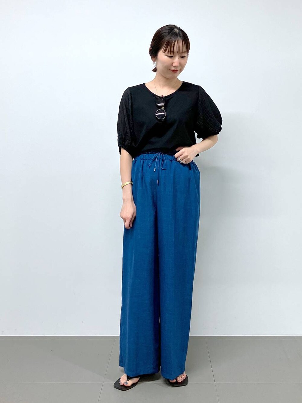 ブラック系のサンダル、ブルー系のその他パンツ、ブラック系のTシャツ/カットソーを着用したレディースの夏コーディネートの2枚目の写真