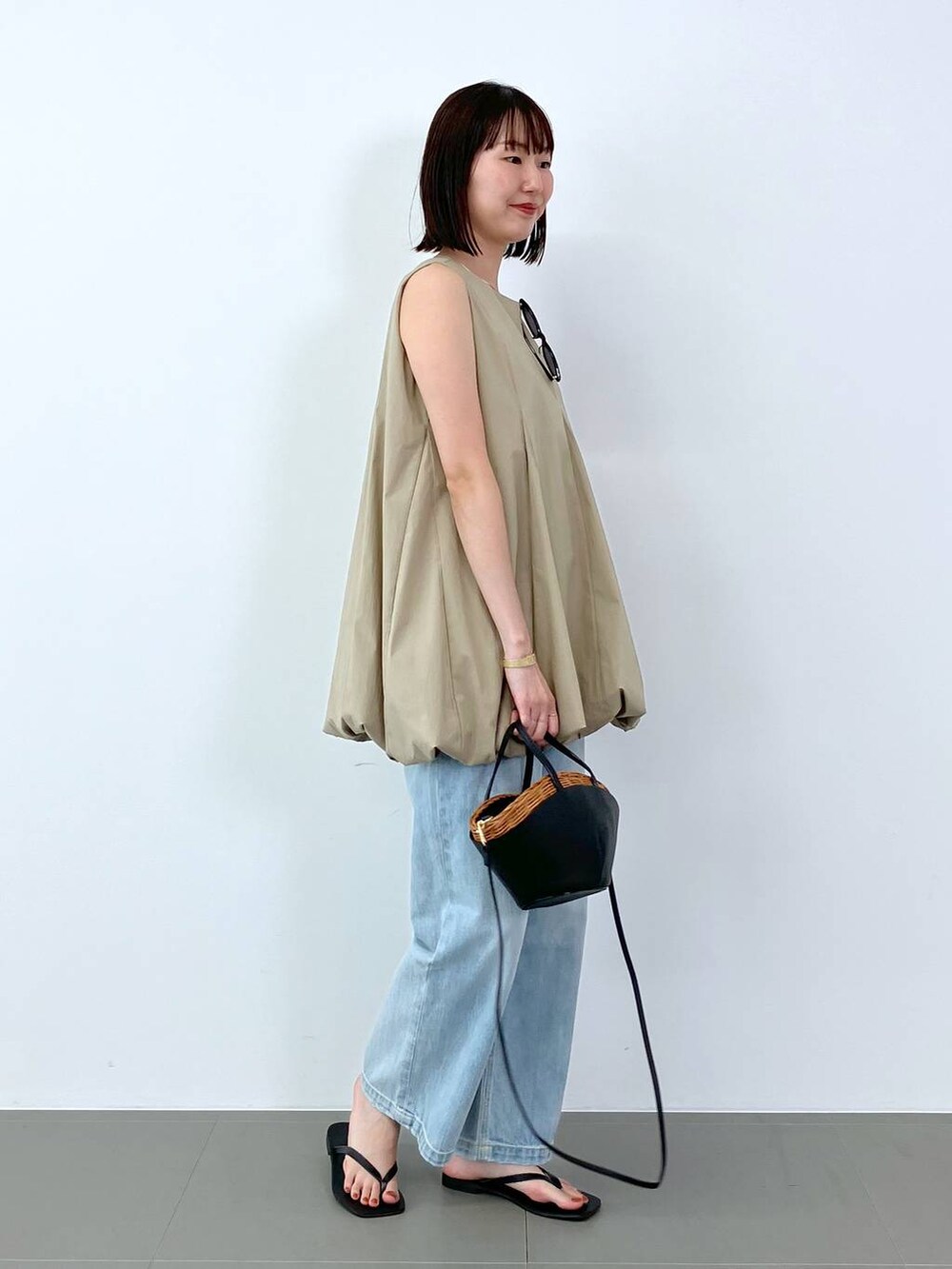 ベージュ系のシャツ/ブラウス、ブルー系のデニムパンツ、ブラック系のサンダルを着用したレディースの夏コーディネートの4枚目の写真