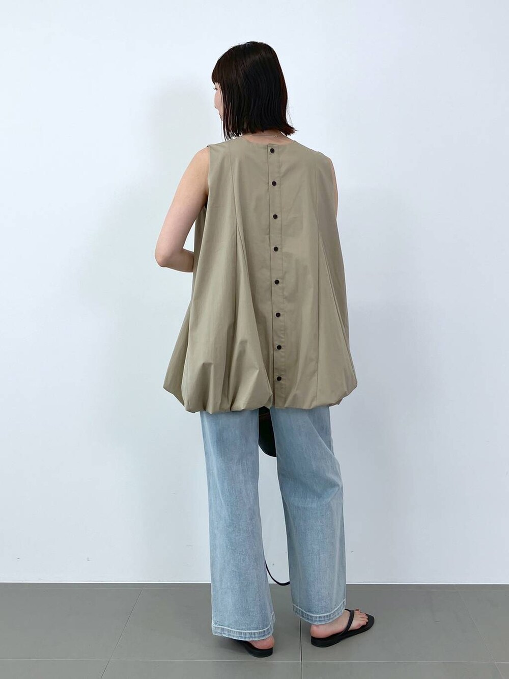 ベージュ系のシャツ/ブラウス、ブルー系のデニムパンツ、ブラック系のサンダルを着用したレディースの夏コーディネートの3枚目の写真