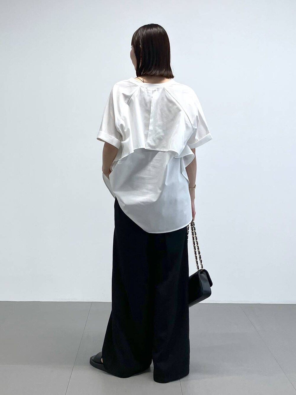 ブラック系のショルダーバッグ、ブラック系のその他パンツ、ホワイト系のシャツ/ブラウスを着用したレディースの夏コーディネートの3枚目の写真