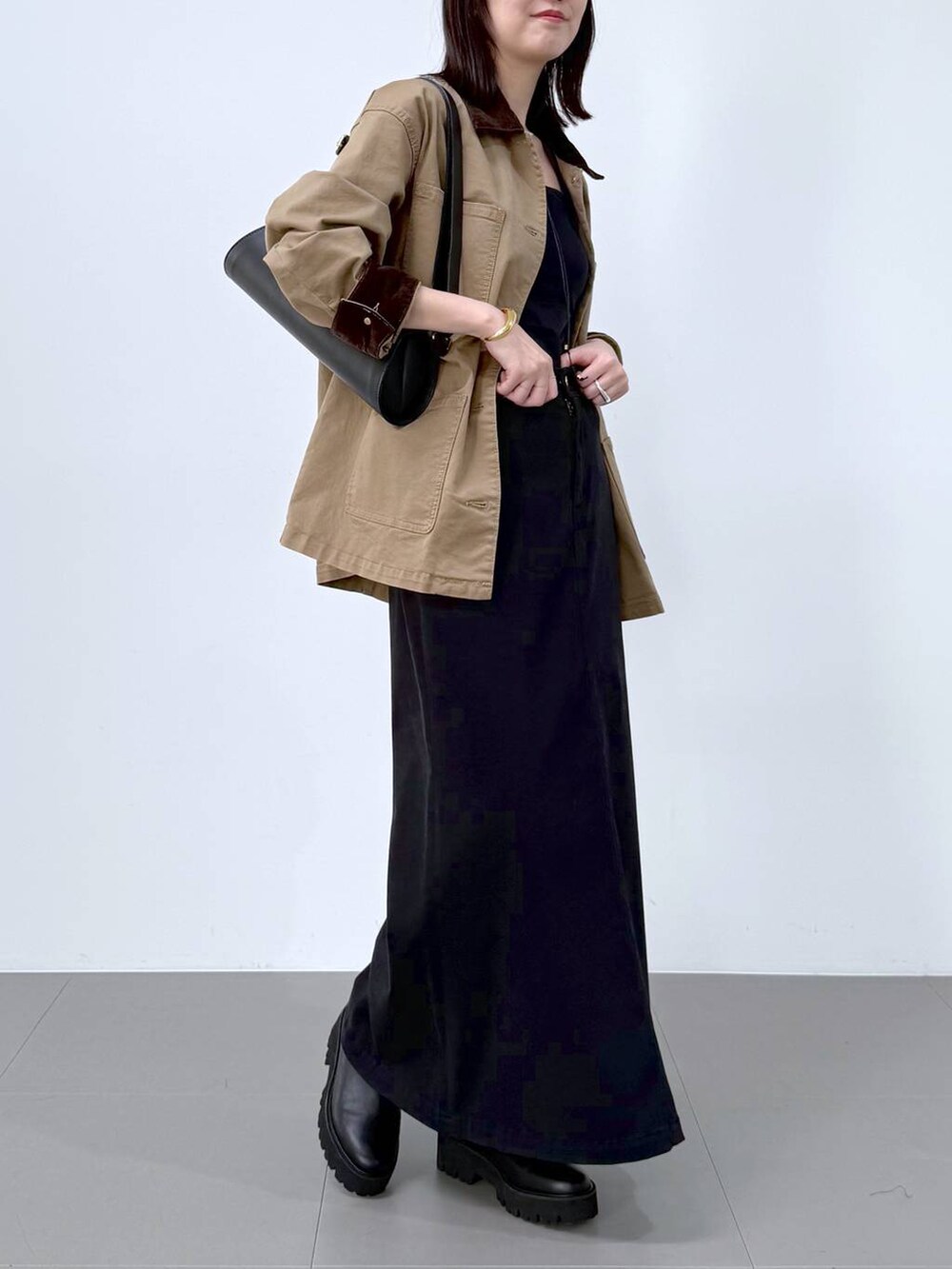 ブラック系のスカート、その他のブーツ、ブラック系のショルダーバッグを着用したレディースの冬コーディネートの5枚目の写真