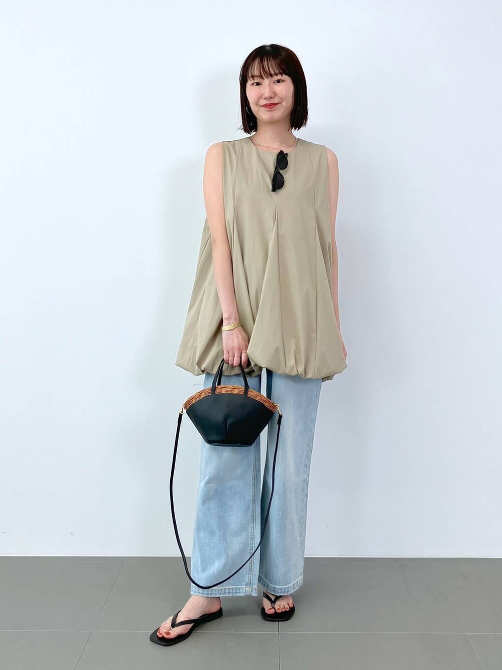 ベージュ系のシャツ/ブラウス、ブルー系のデニムパンツ、ブラック系のサンダルを着用したレディースの夏コーディネートの2枚目の写真