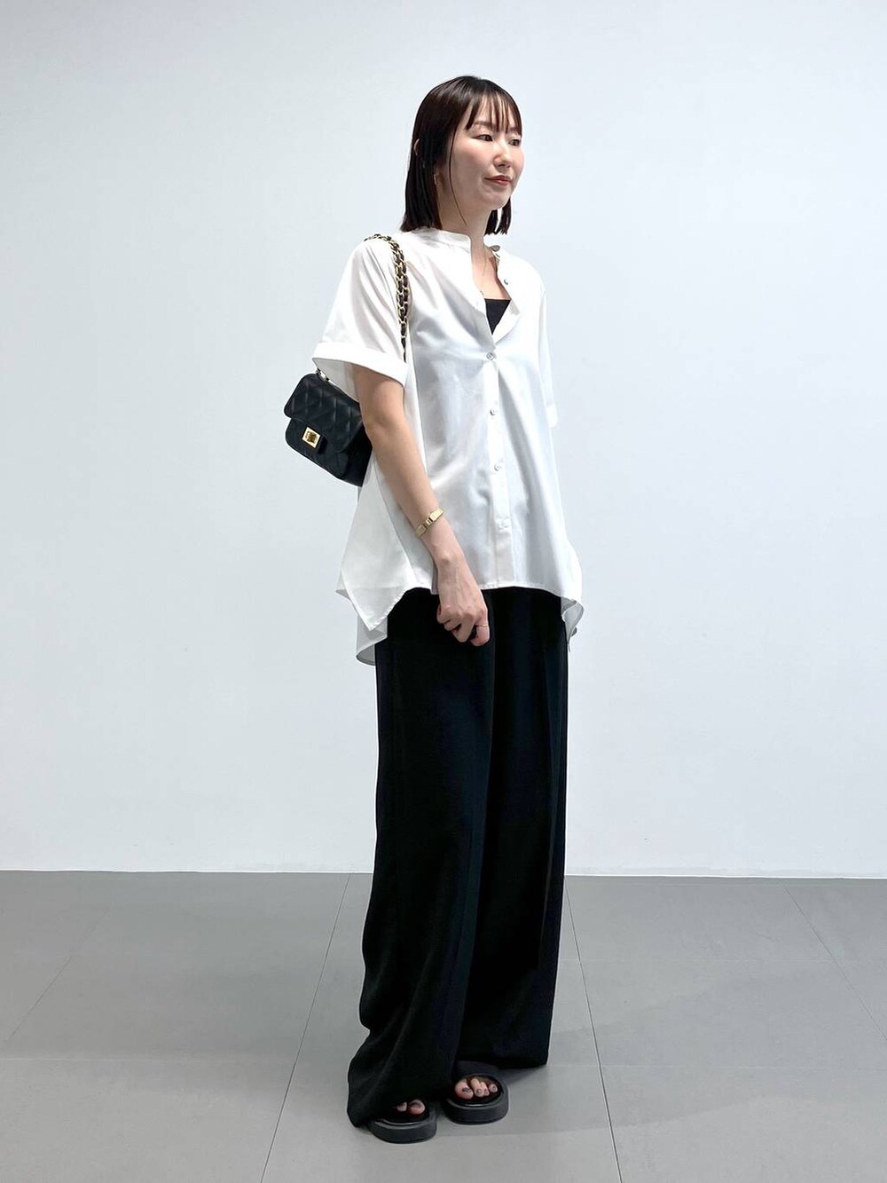 ブラック系のショルダーバッグ、ブラック系のその他パンツ、ホワイト系のシャツ/ブラウスを着用したレディースの夏コーディネートの5枚目の写真
