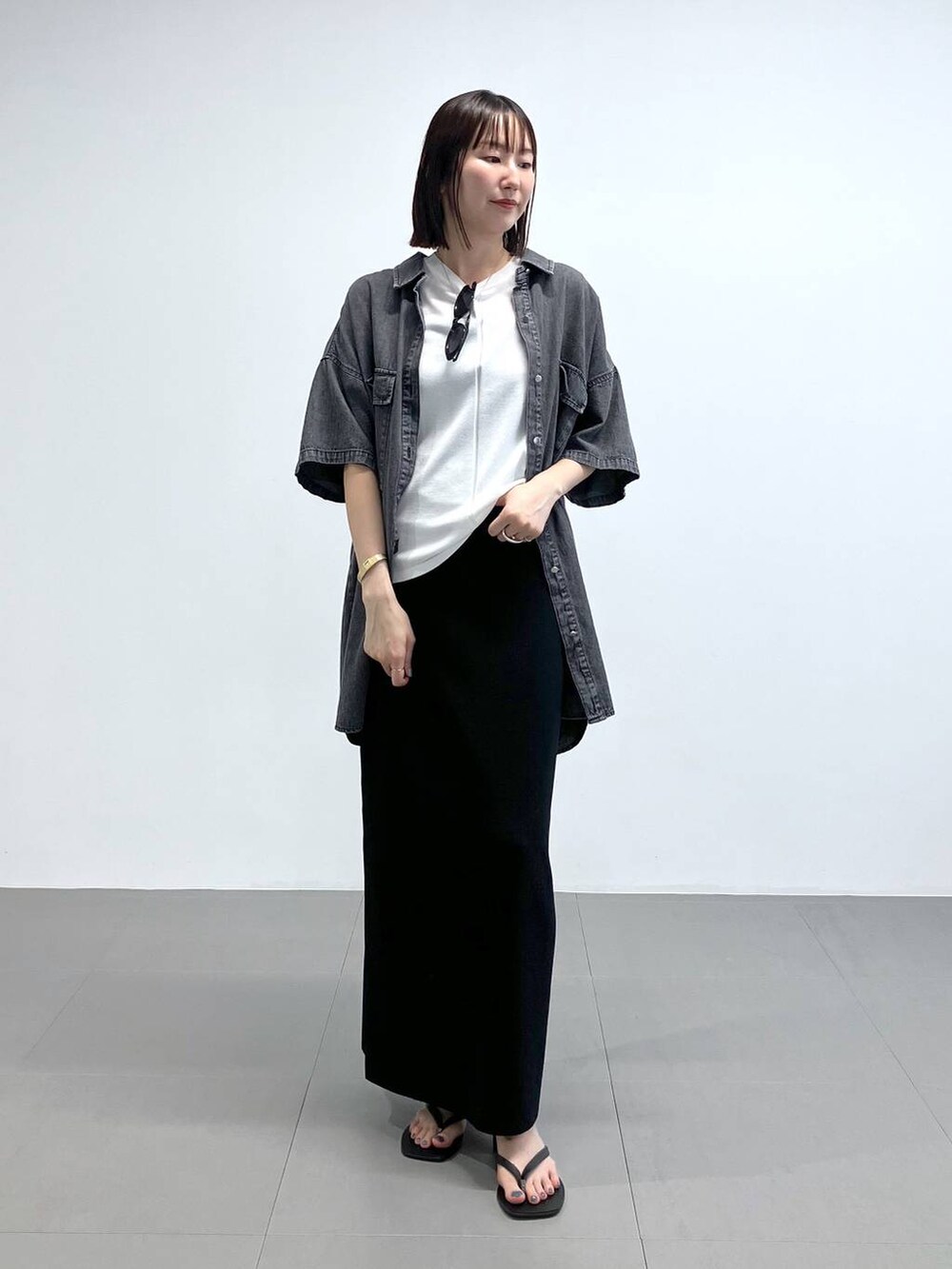 ブラック系のサンダル、ブラック系のシャツ/ブラウス、ブラック系のスカートを着用したレディースの夏コーディネートの2枚目の写真