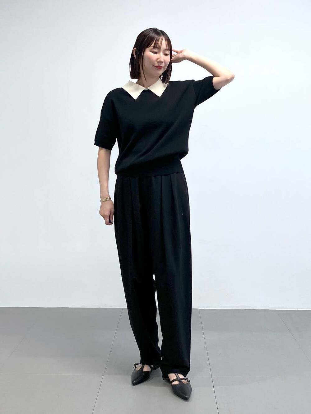 ブラック系のスラックス、ブラック系のニット/セーターを着用したレディースの夏コーディネートの2枚目の写真