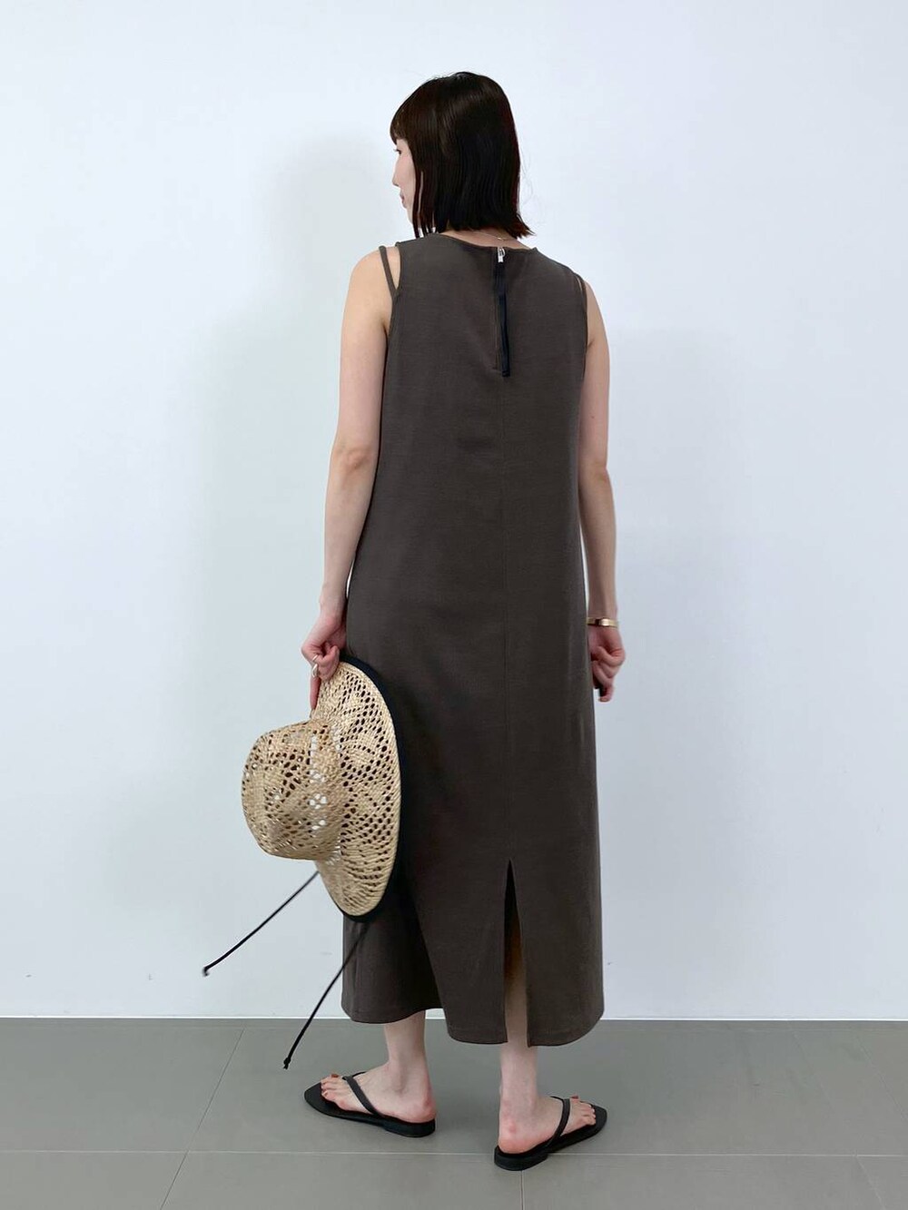 ブラック系のサンダル、ブラウン系のワンピース、ベージュ系のハットを着用したレディースの夏コーディネートの4枚目の写真