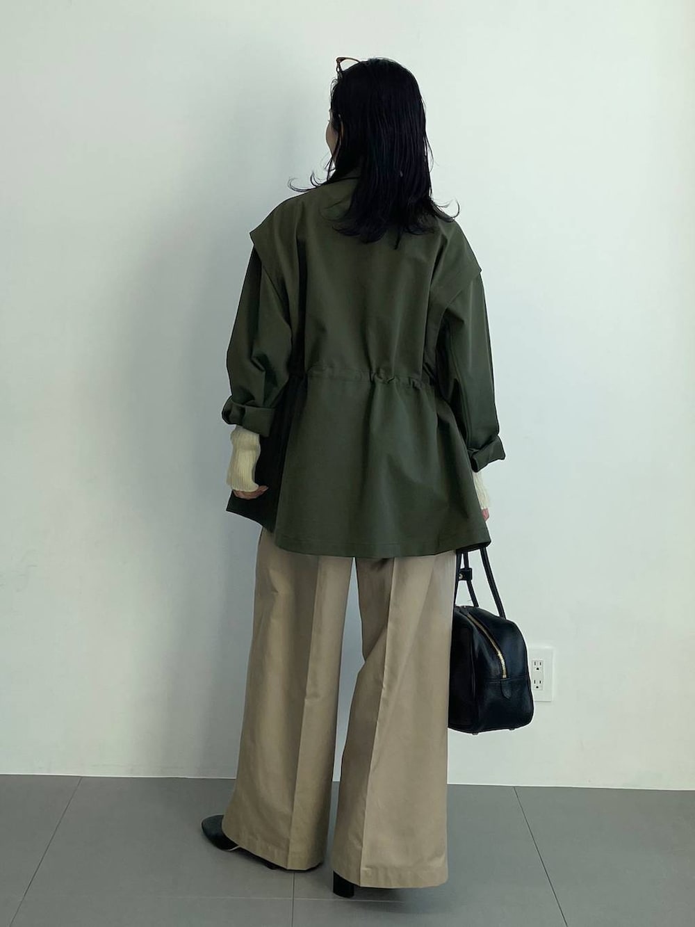 ブラック系のブーツ、ベージュ系のチノパンツ、イエロー系のニット/セーターを着用したレディースの冬コーディネートの6枚目の写真