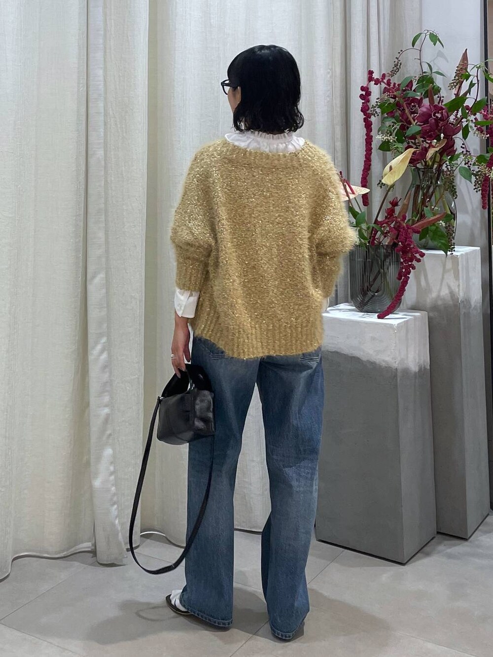 ブルー系のデニムパンツ、ブラウン系のサンダル、ホワイト系のシャツ/ブラウスを着用したレディースの秋コーディネートの6枚目の写真