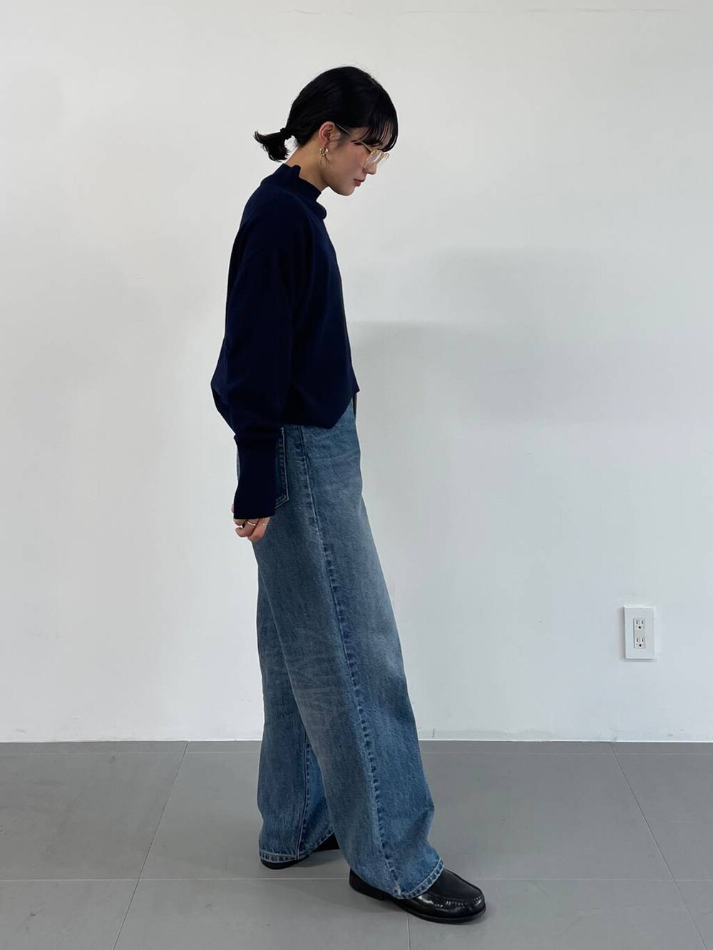 ブルー系のデニムパンツ、ブラック系のローファー、ブルー系のニット/セーターを着用したレディースの冬コーディネートの3枚目の写真