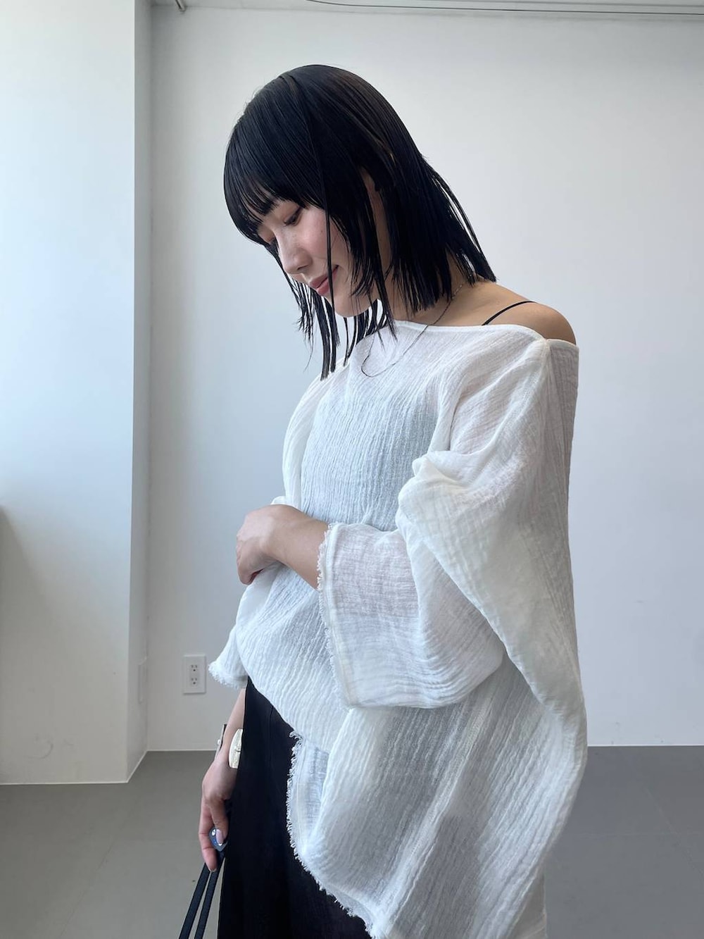 ベージュ系のかごバッグ、ブラウン系のスカート、ホワイト系のニット/セーターを着用したレディースの春コーディネートの4枚目の写真
