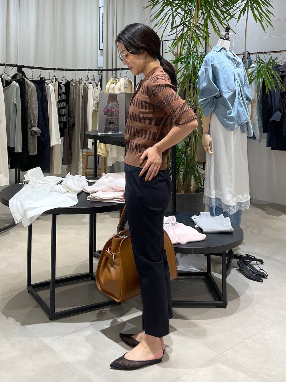 ブラック系のパンプス、ブラウン系のボストンバッグ、ブラック系のその他パンツを着用したレディースの春コーディネートの4枚目の写真