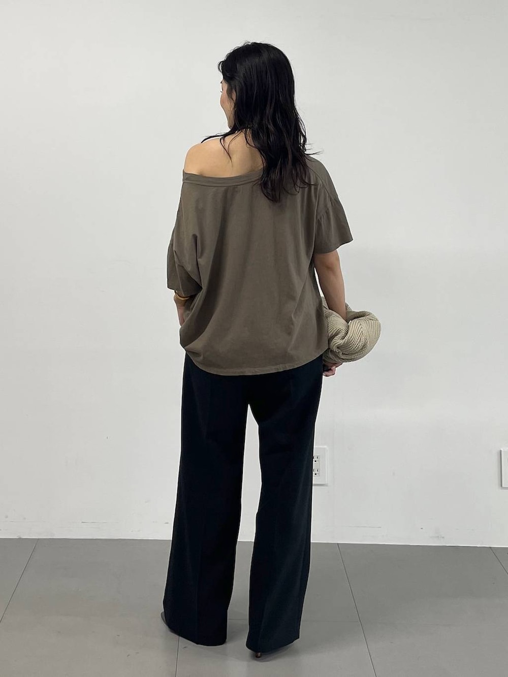 ブラック系のスラックス、グリーン系のTシャツ/カットソー、ブラック系のサンダルを着用したレディースの夏コーディネートの4枚目の写真