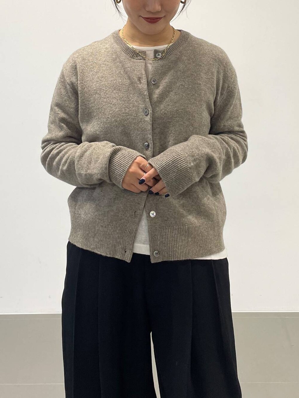 ホワイト系のハンドバッグ、ブラック系のその他パンツ、グリーン系のニット/セーターを着用したレディースの秋コーディネートの6枚目の写真