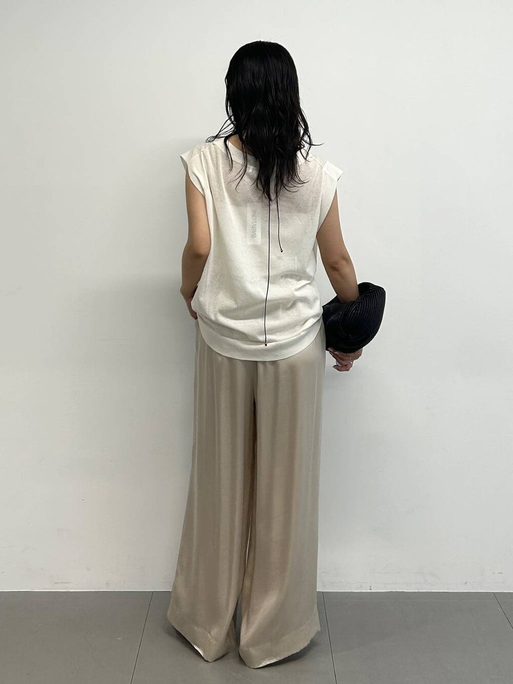 ベージュ系のその他パンツ、ホワイト系のTシャツ/カットソー、ブラック系のサンダルを着用したレディースの夏コーディネートの5枚目の写真