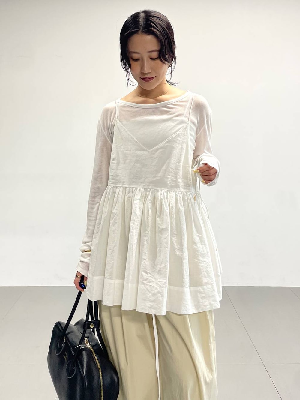 ブラック系のサンダル、ホワイト系のTシャツ/カットソー、ホワイト系のキャミソールを着用したレディースの春コーディネートの5枚目の写真