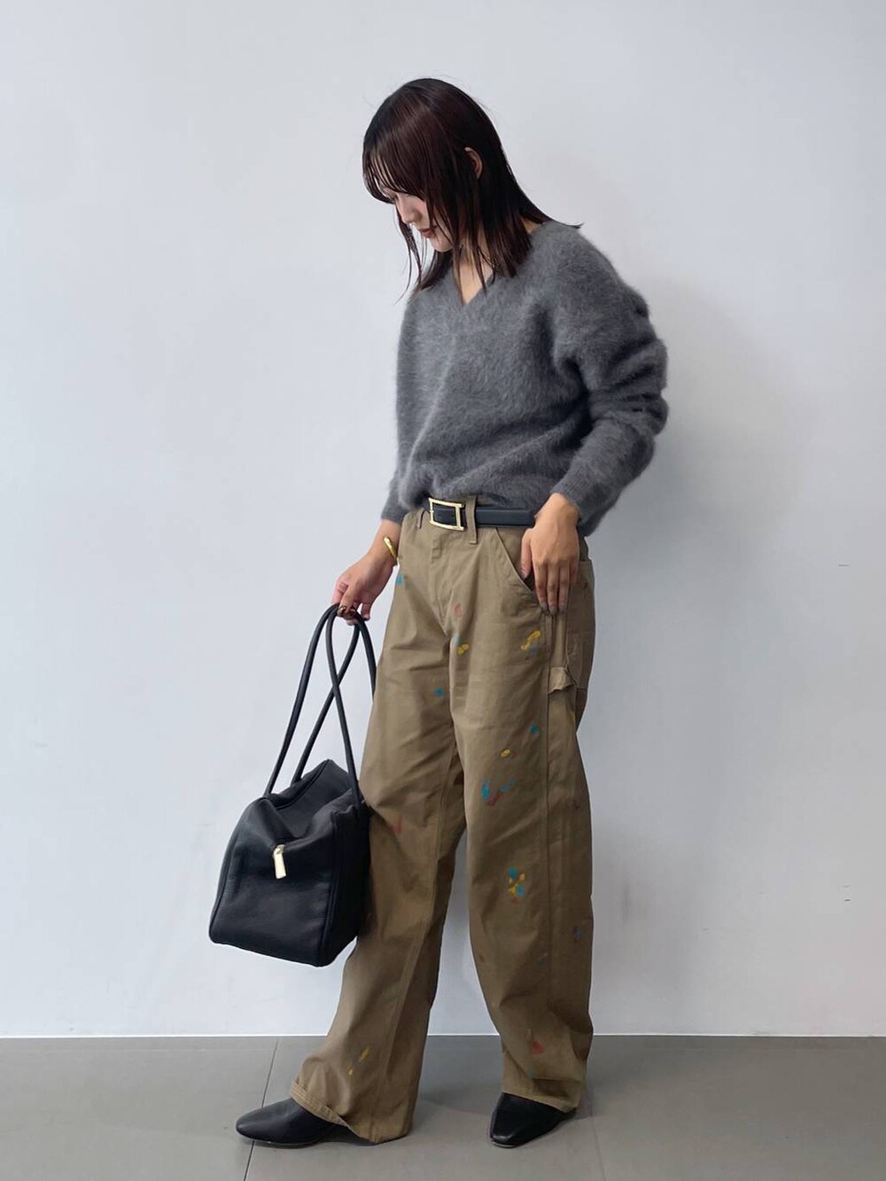 グレー系のニット/セーター、ブラック系のボストンバッグ、ブラック系のブーツを着用したレディースの秋コーディネートの3枚目の写真