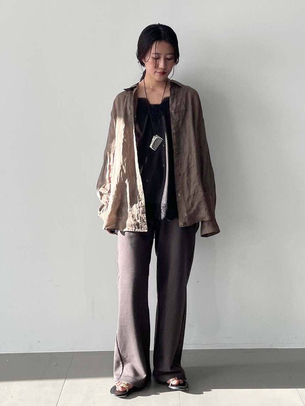 グリーン系のシャツ/ブラウス、ブラック系のキャミソール、グレー系のスウェットパンツを着用したレディースの春コーディネートの2枚目の写真