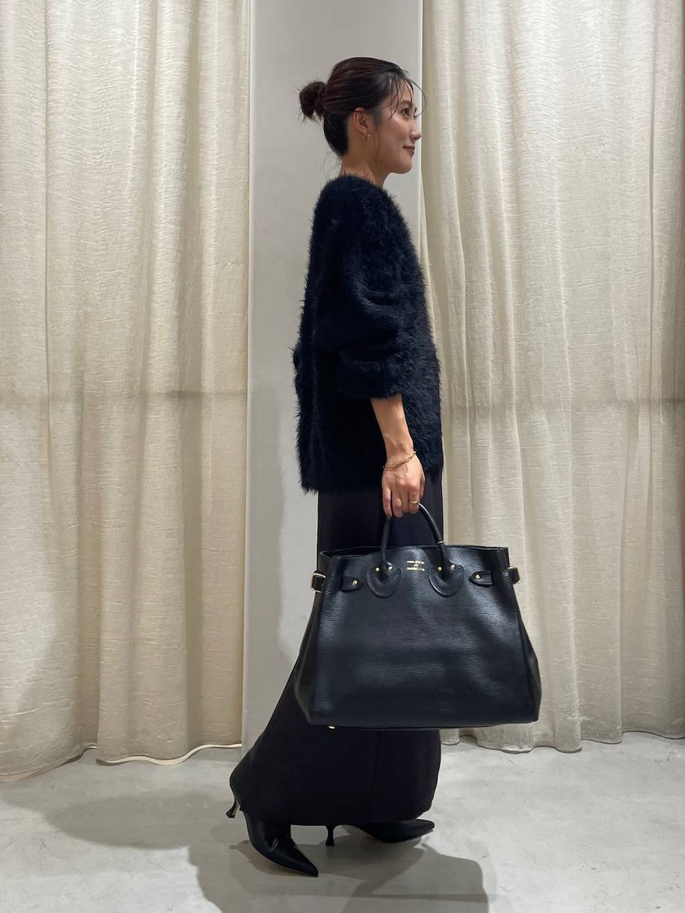 ブラック系のカーディガン/ボレロ、グレー系のスカート、ブラック系のハンドバッグを着用したレディースの秋コーディネートの4枚目の写真