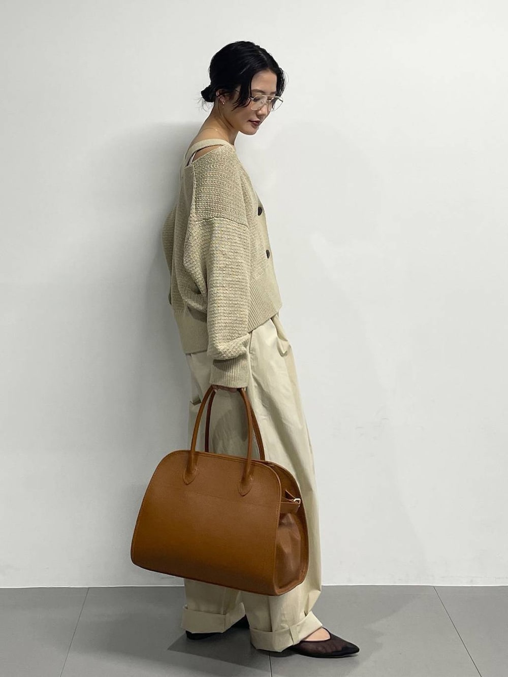 ブラック系のパンプス、ベージュ系のカーディガン/ボレロ、ブラウン系のボストンバッグを着用したレディースの春コーディネートの3枚目の写真