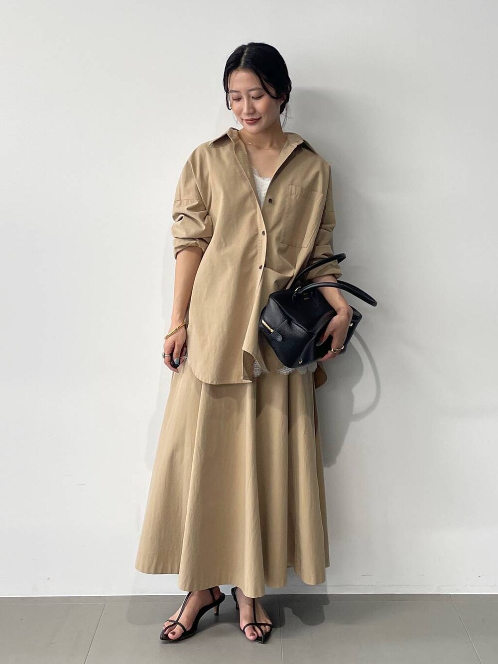 ブラック系のサンダル、ベージュ系のスカート、ベージュ系のシャツ/ブラウスを着用したレディースの春コーディネートの3枚目の写真