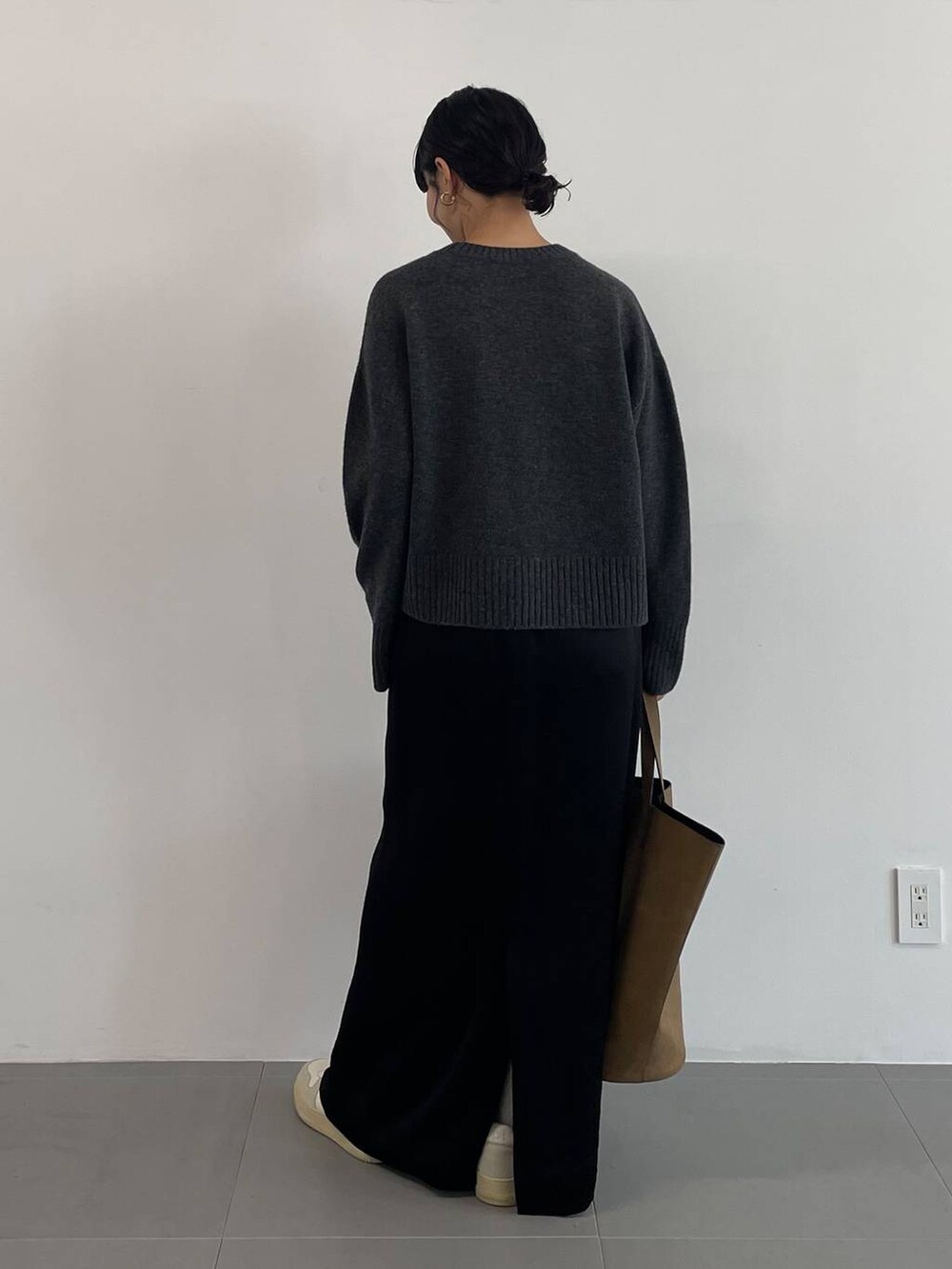 ブラウン系のトートバッグ、ブラック系のスカート、グレー系のニット/セーターを着用したレディースの冬コーディネートの4枚目の写真