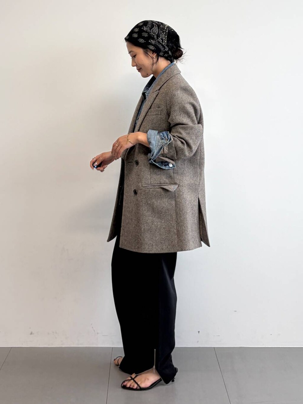 ブルー系のスウェットパンツ、ブルー系のデニムジャケット、ブラック系のサンダルを着用したレディースの秋コーディネートの2枚目の写真